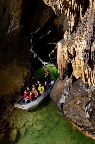 Grotte de Labouiche (Ariège) - Groupe de touristes dans une barque admirant les concrétions (plan rapproché)(SP-23-1583)